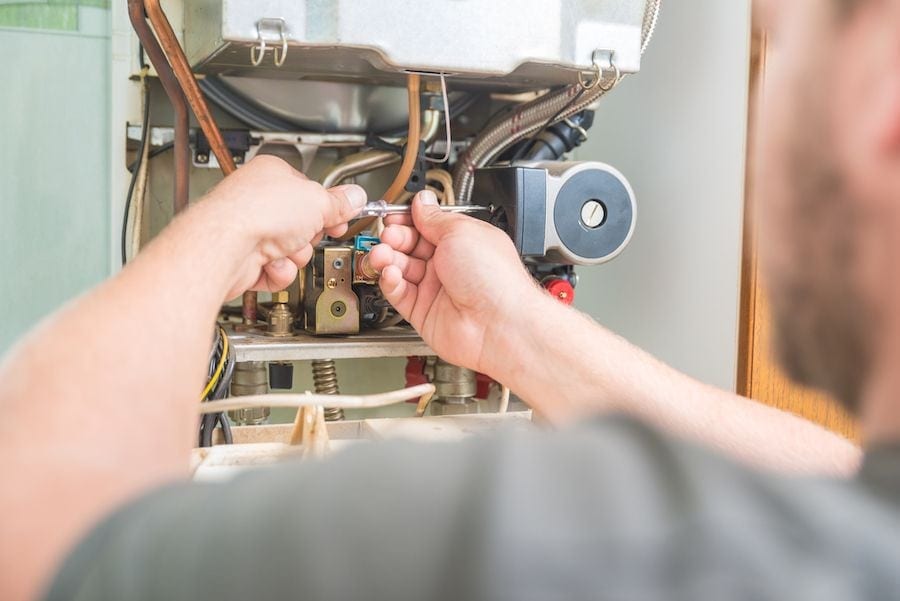 Image of someone working on a furnace. How Do I Know When I Need a New Furnace?