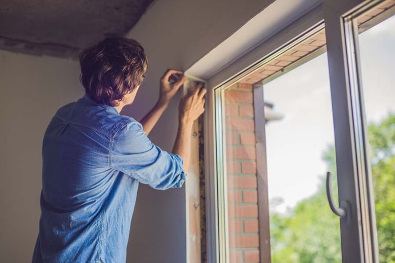 man insulating window